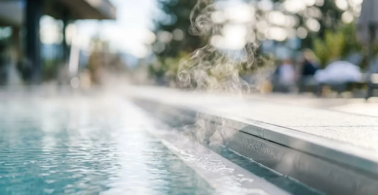 Gros plan sur de la vapeur s'élevant d'une piscine extérieure chauffée, avec des reflets d'eau et une ambiance zen de spa de montagne